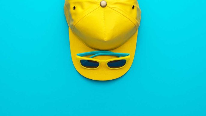 Image d'une casquette et d'une paire de lunette en guise d'objet publicitaire pour booster sa communication sur fond bleu