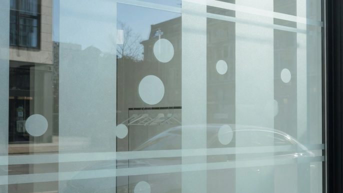 Vitrine de commerce avec film de vitrophanie dépoli et transparent appliqué sur la surface vitrée